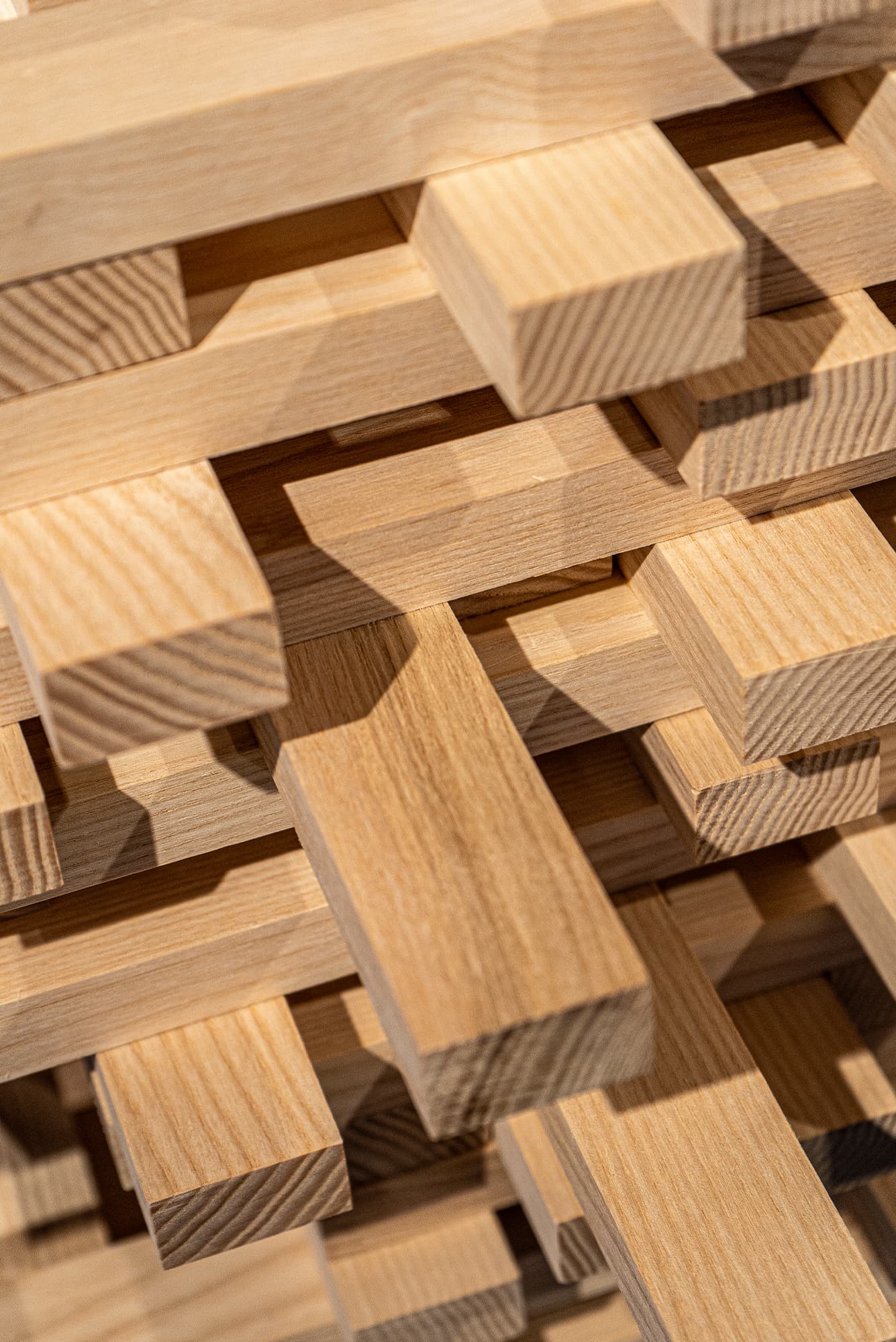 Precyzyjnie ułożone w stos, strugane kantówki drewniane o gładkiej powierzchni i jasnym usłojeniu.