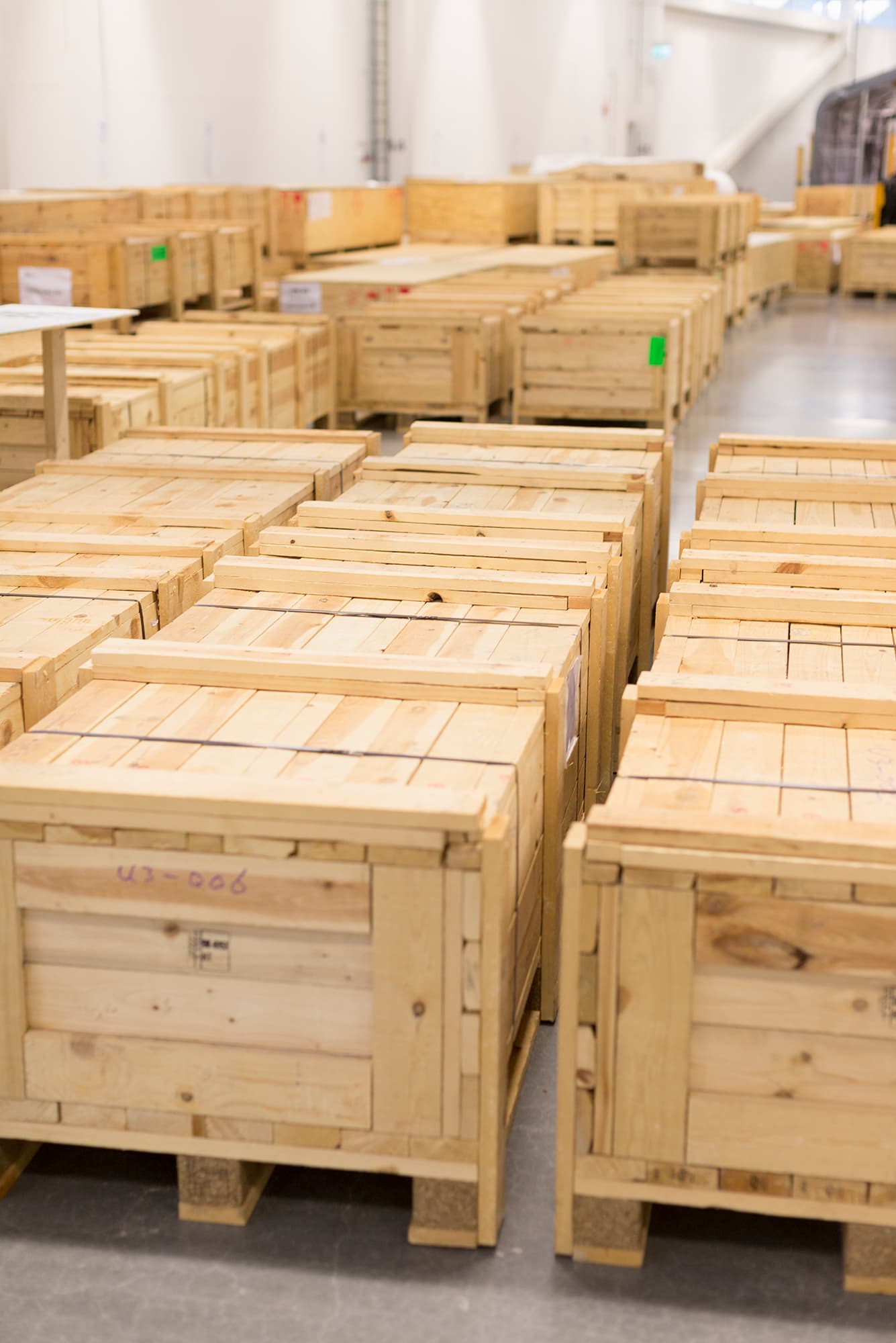 Magazyn producenta ze sztaplowanymi nowymi skrzyniami drewnianymi transportowymi gotowymi do wysyłki.