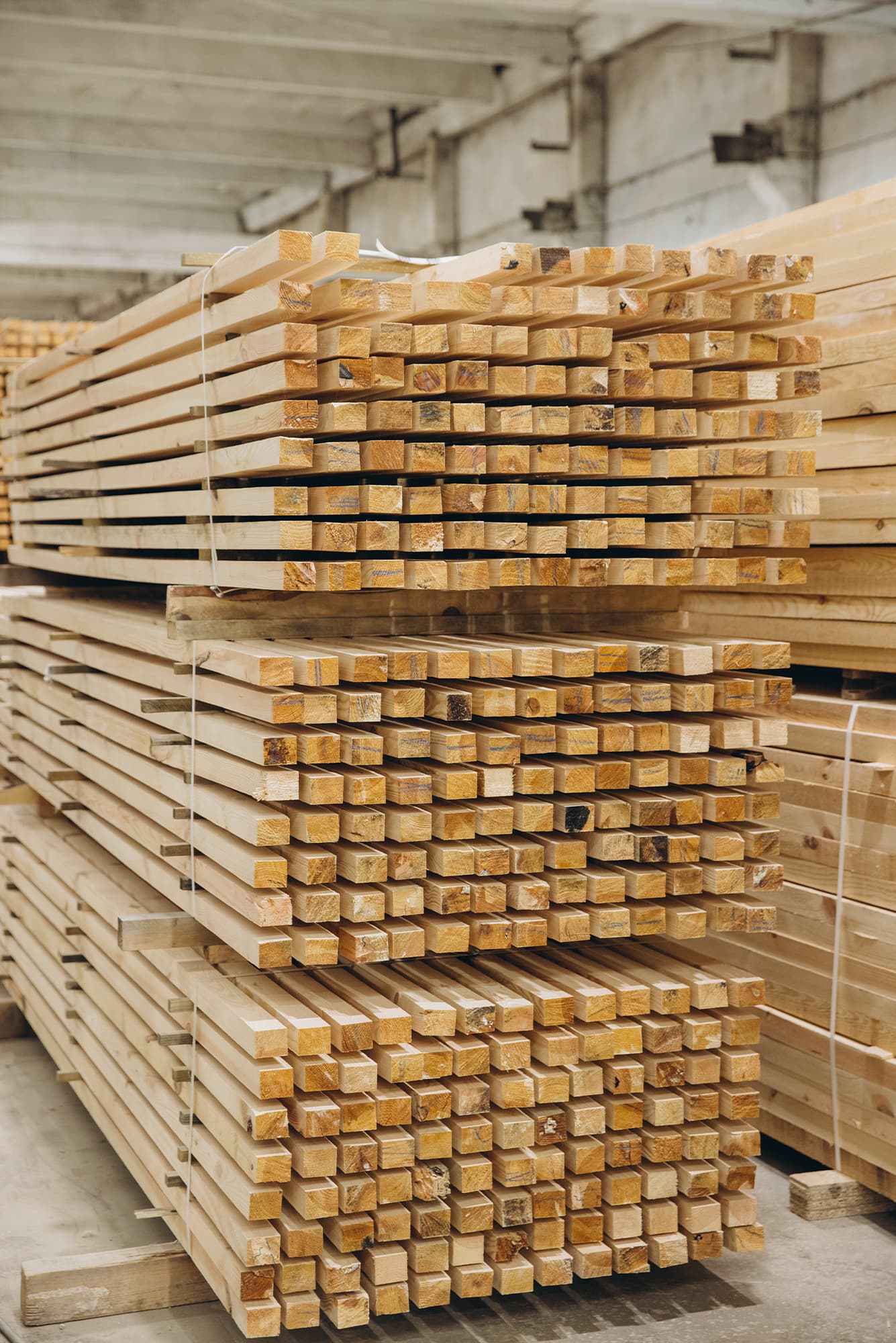Starannie ułożona tarcica iglasta w hali. Kantówki i drewno konstrukcyjne przygotowane do transportu na budowę.